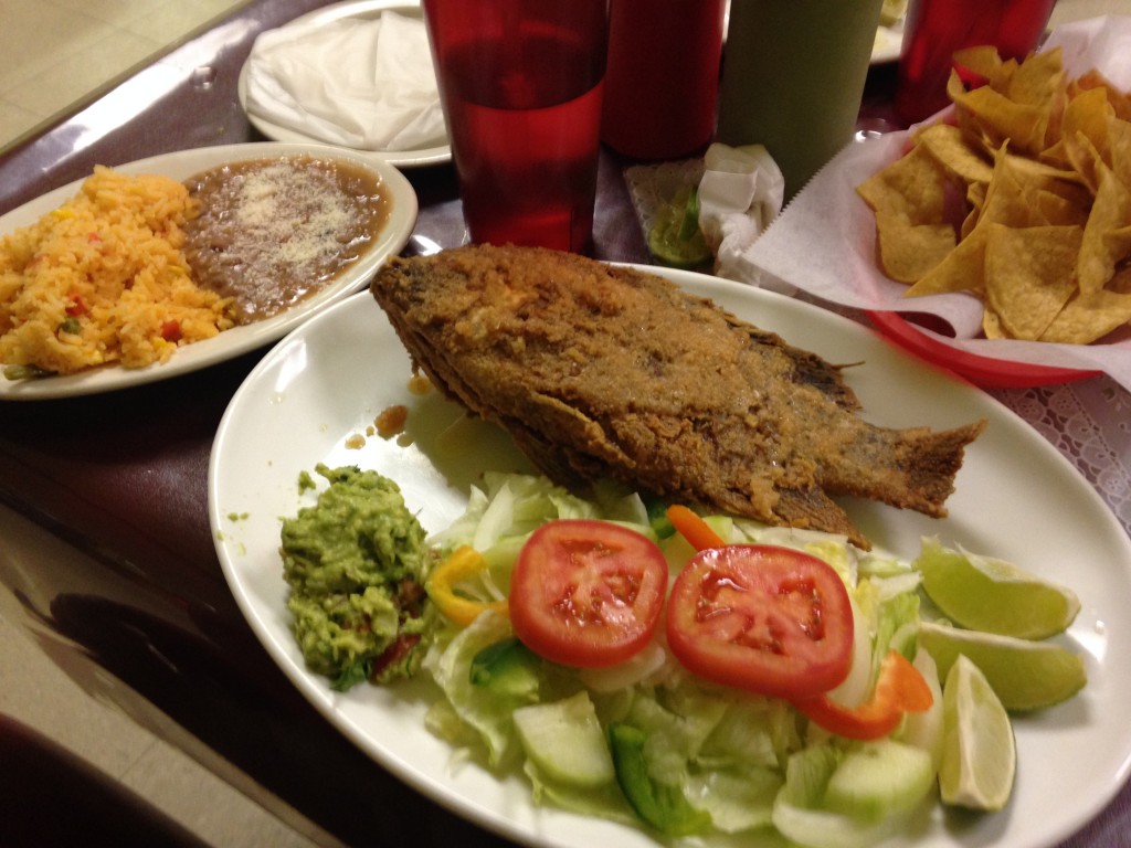fried tilapia dinner with salad, rice, beans, and chips