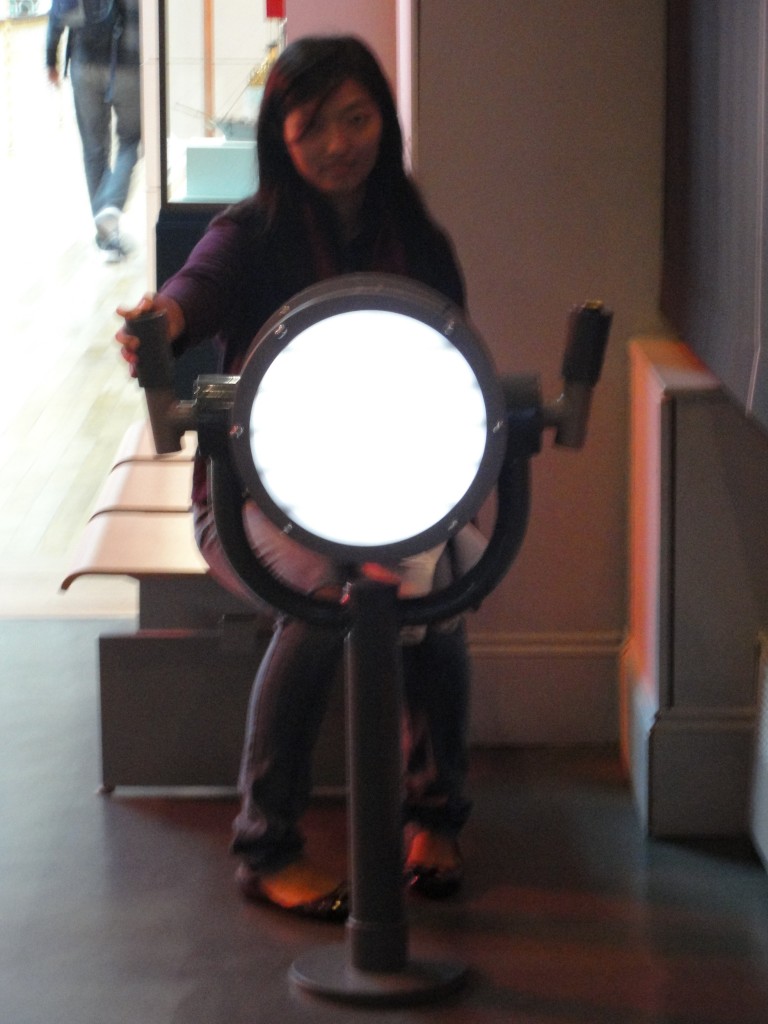 girl sitting in museum using giant light to signal morse code
