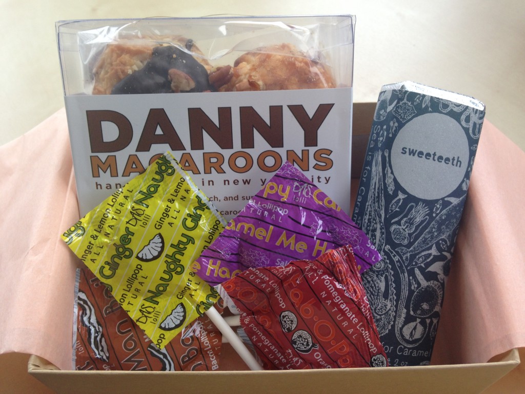treatsie november box contents with macaroons, chocolate bar, and lollipops