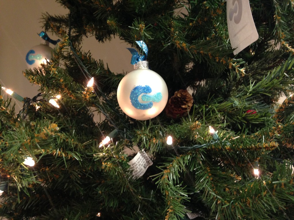 white canvas ornament with company logo hanging on christmas tree