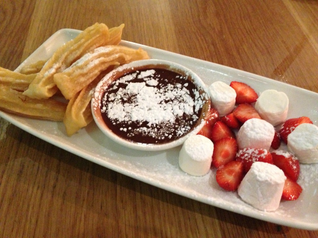 churros with chocolate sauce, strawberries, marshmallows, and powdered sugar at la tasca restaurant in london