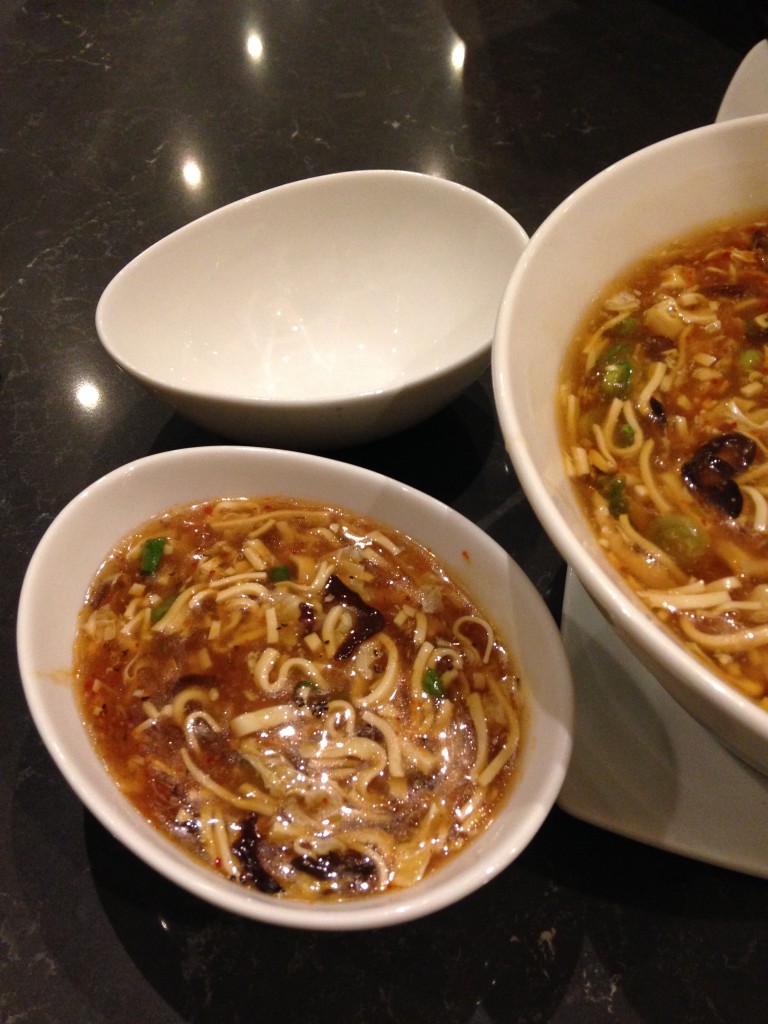 din tai fung hot and sour soup in small bowl next to large bowl