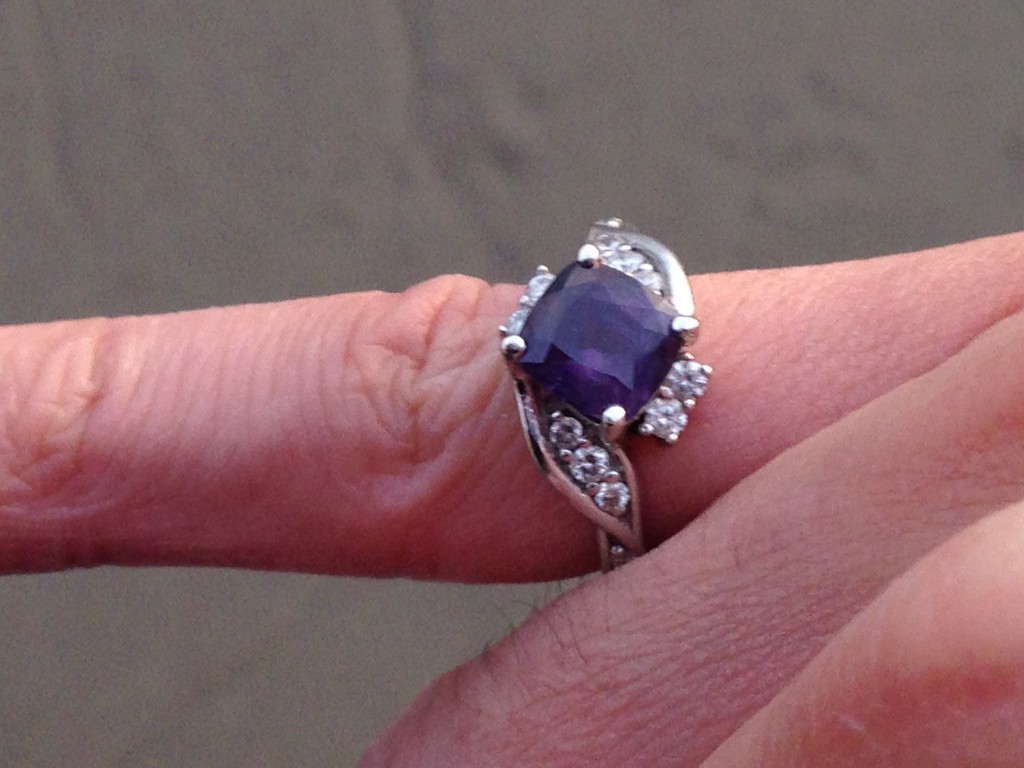 engagement ring with purple sapphire center stone worn on guy's pinky finger