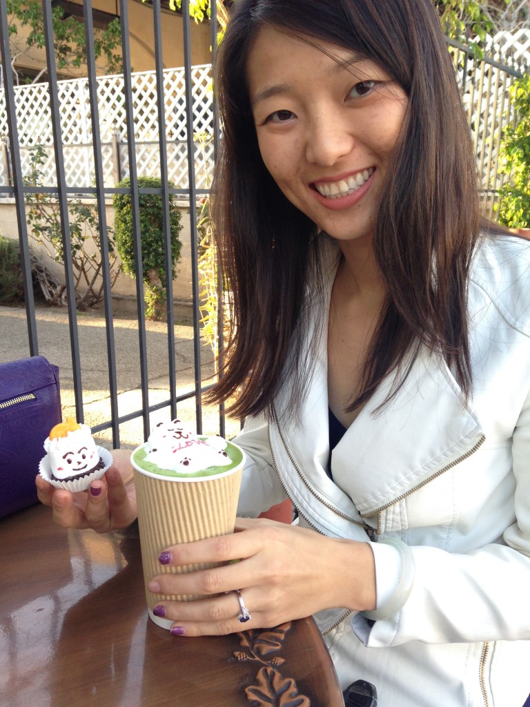 girl holding drink with latte art and decorated marshmallow