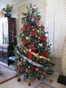 christmas tree in living room decorated with poinsettias and ornaments