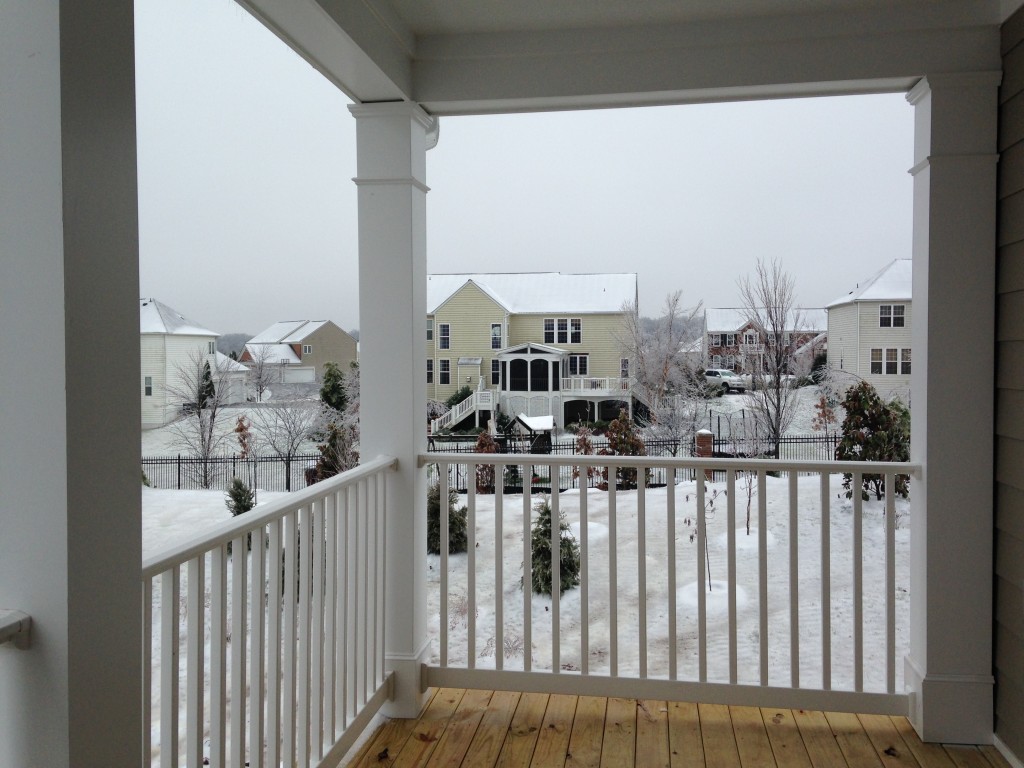 new condo porch with white railing and view of houses in back