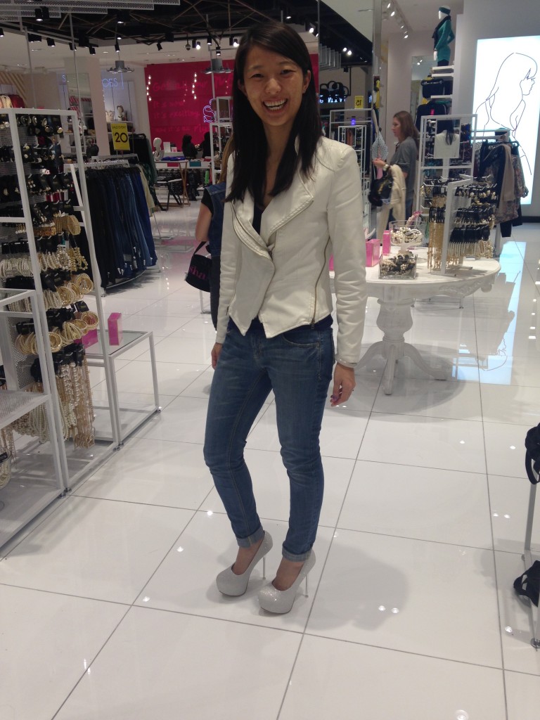 girl laughing trying on white glittery platform heels in store
