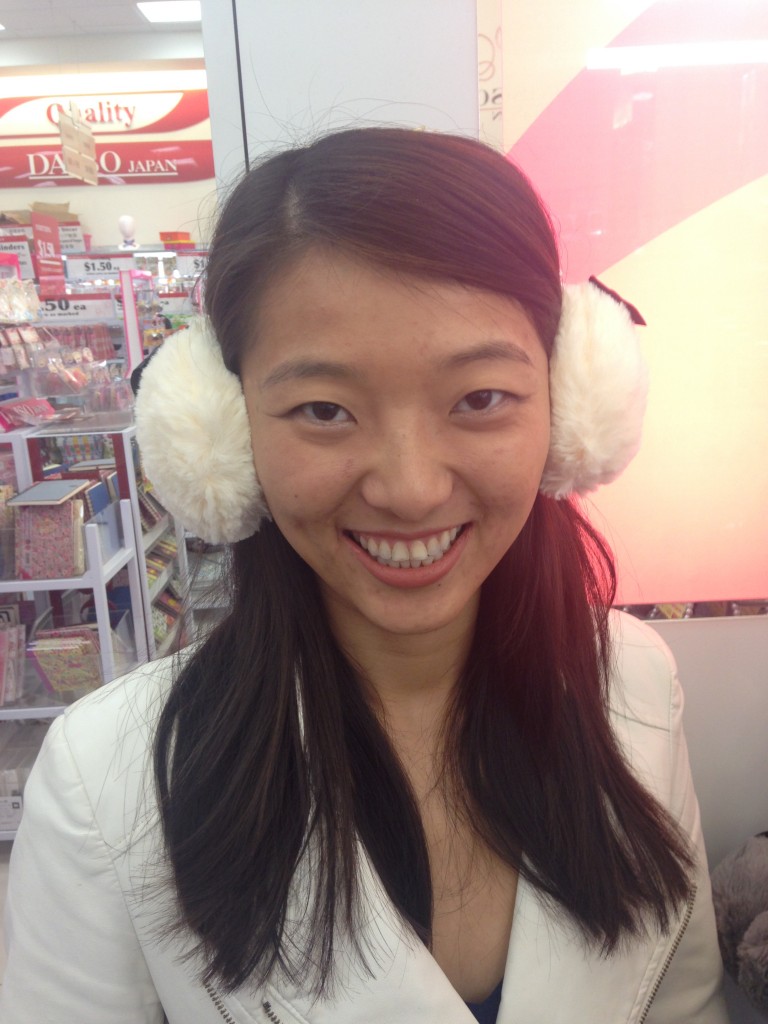 girl wearing white fuzzy earmuffs in store