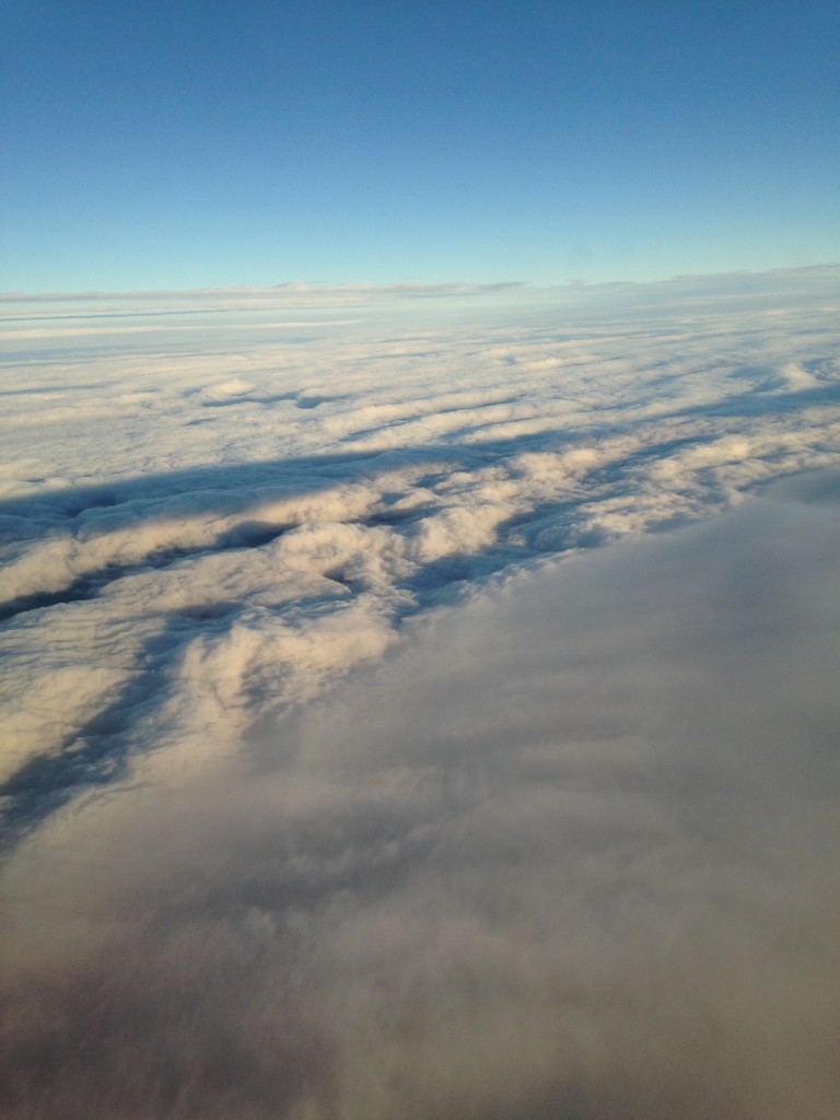 overhead view of gray clouds and white clouds with shadows of setting sun