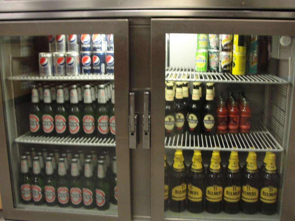 fridge with glass doors showing sodas and beers inside