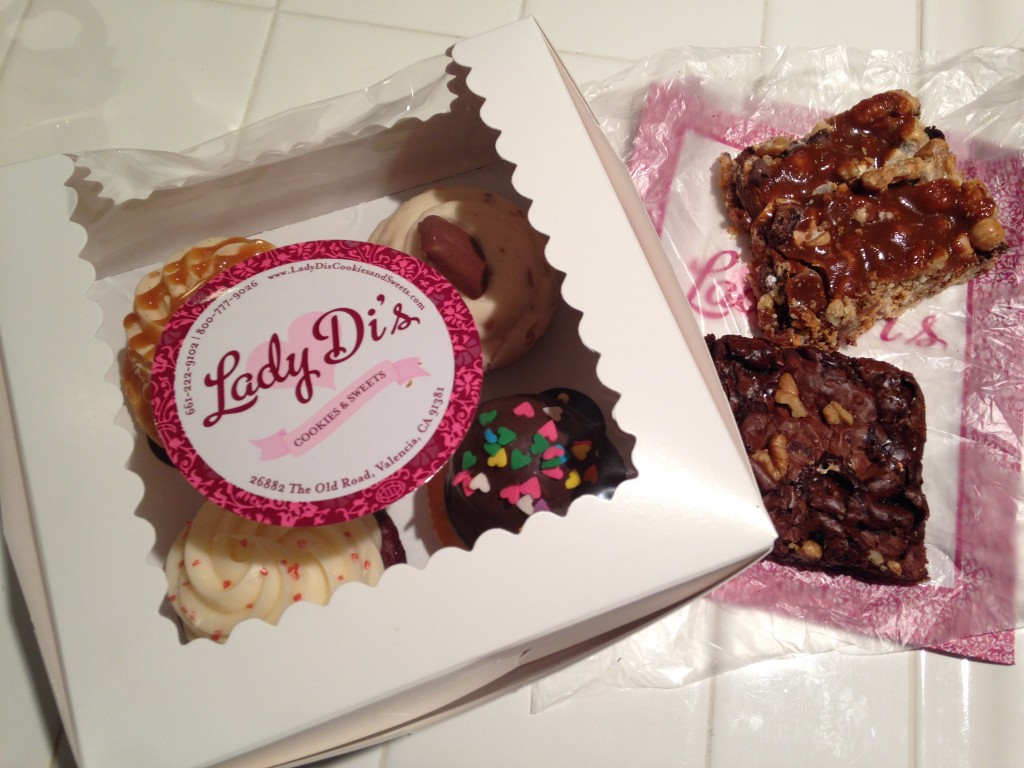 box of lady di's cupcakes and two brownies on side