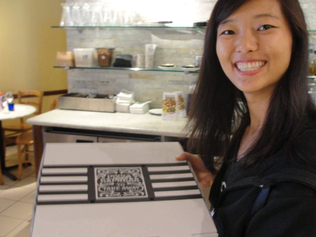 girl happily holding pizza express takeout box