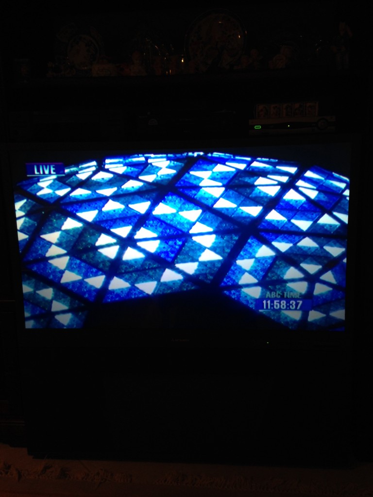 zoomed in view of times square new years ball lit up in blue on tv for new years eve celebration in nyc