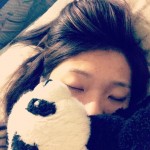 girl sleeping with toy panda covering part of face