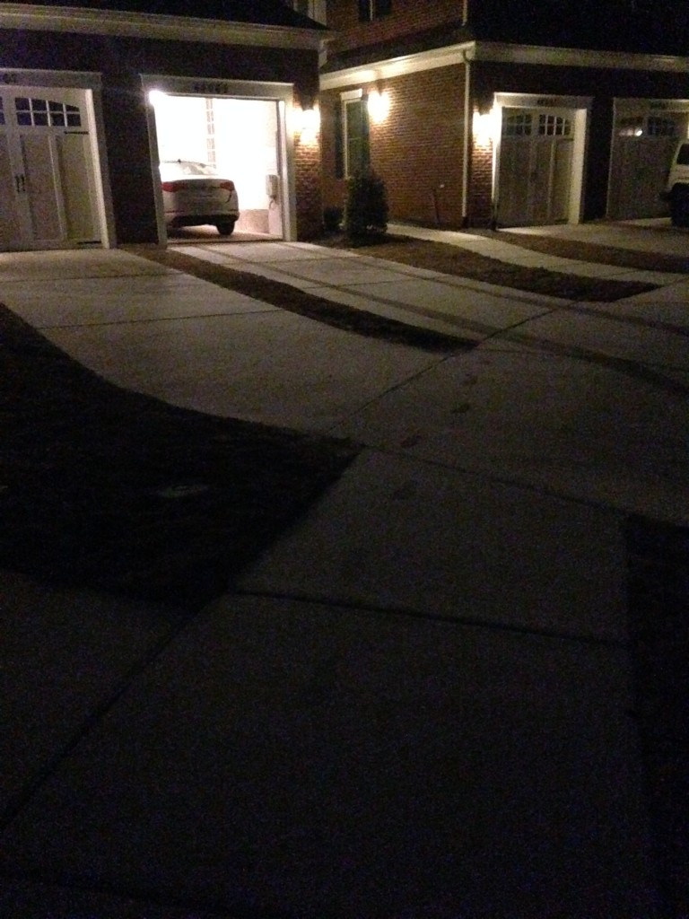light dusting of snow on driveway and sidewalk with footprints