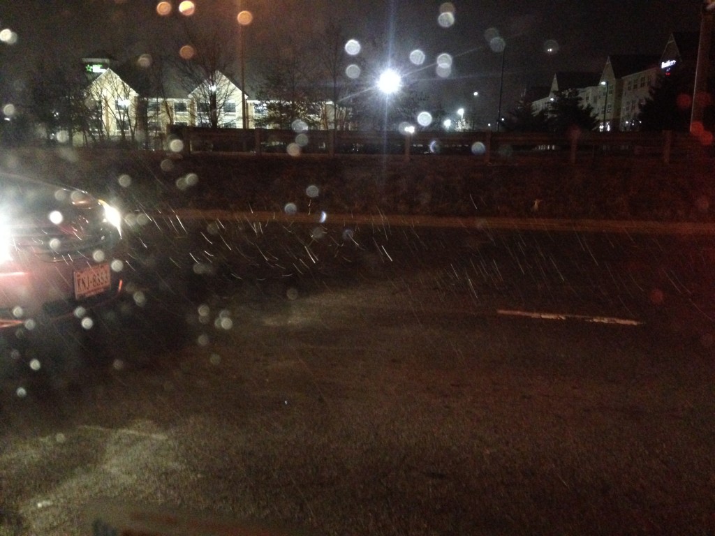 beginning of snow storm with flakes falling on road