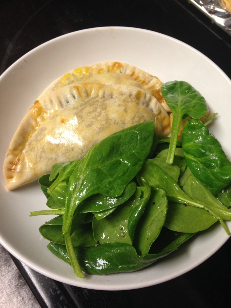 plate of spinach and cauliflower empanadas with spinach salad