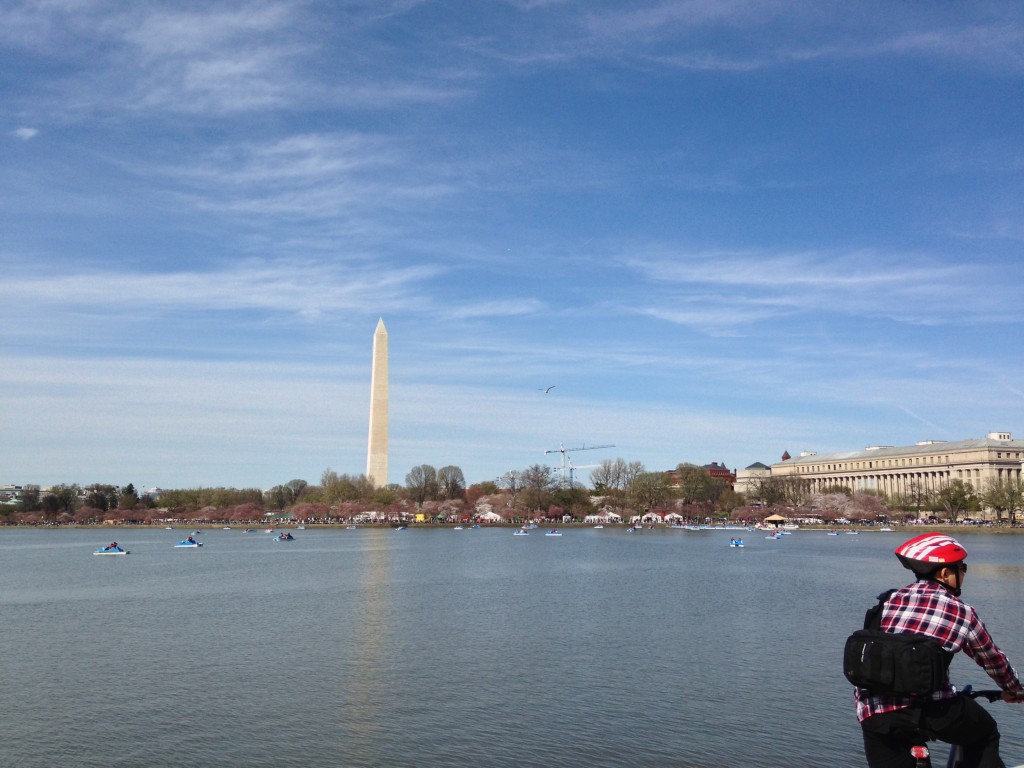view of cherry blossom festival booths and washington monument across tidal basin