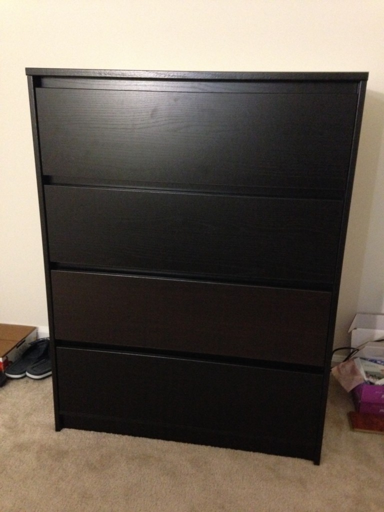 black 4-drawer dresser newly assembled but with one brown drawer