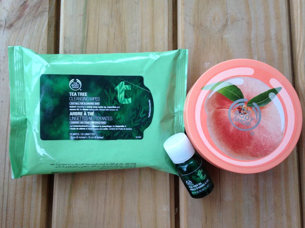 the body shop tea tree oil cleansing wipes, bottle of tea tree oil, and vineyard peach body butter