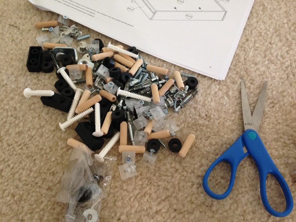 pile of screws, dowels, cams, and other hardware for dresser