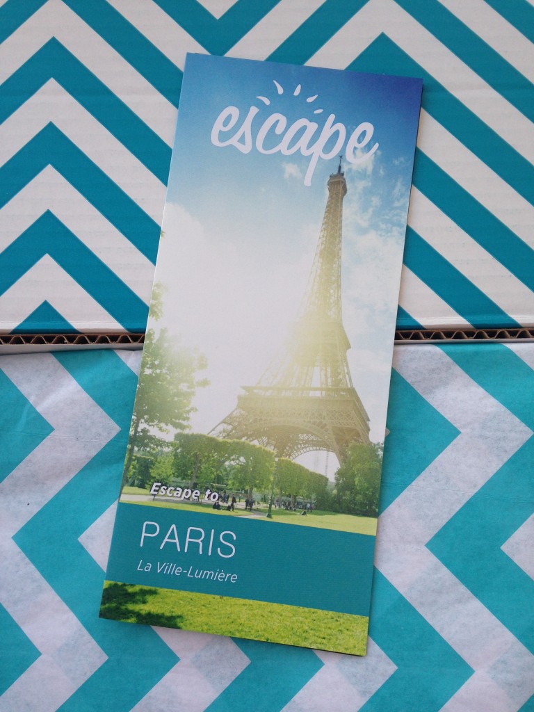 escape monthly august paris box info card against blue and white chevron background
