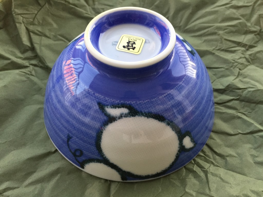 small blue bowl with back of cartoon pig outline on side