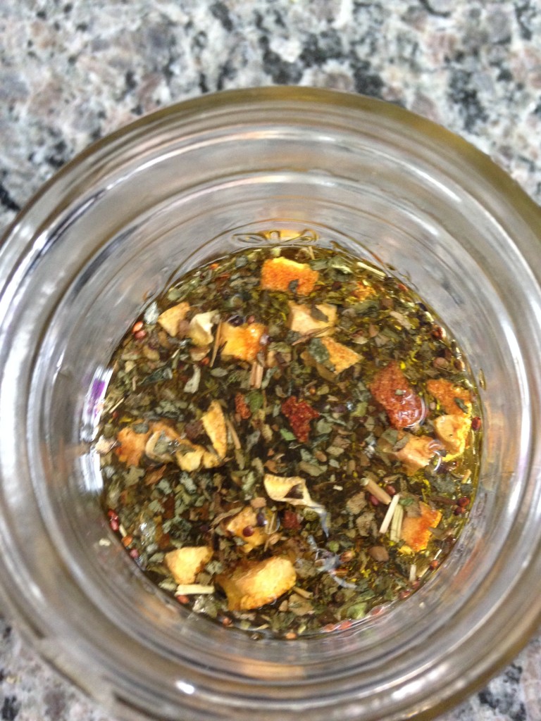 olive oil infusion in jar with lemon peel and basil leaf