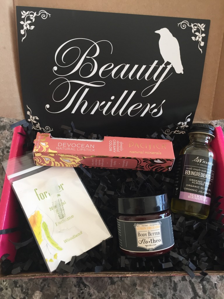 contents of petit vour october 2014 box with pacificia devocean natural lipstick, forager botanicals natural eau de perfume, flo + theo body butter, sw basics makeup remover, and info card with beauty thrillers theme