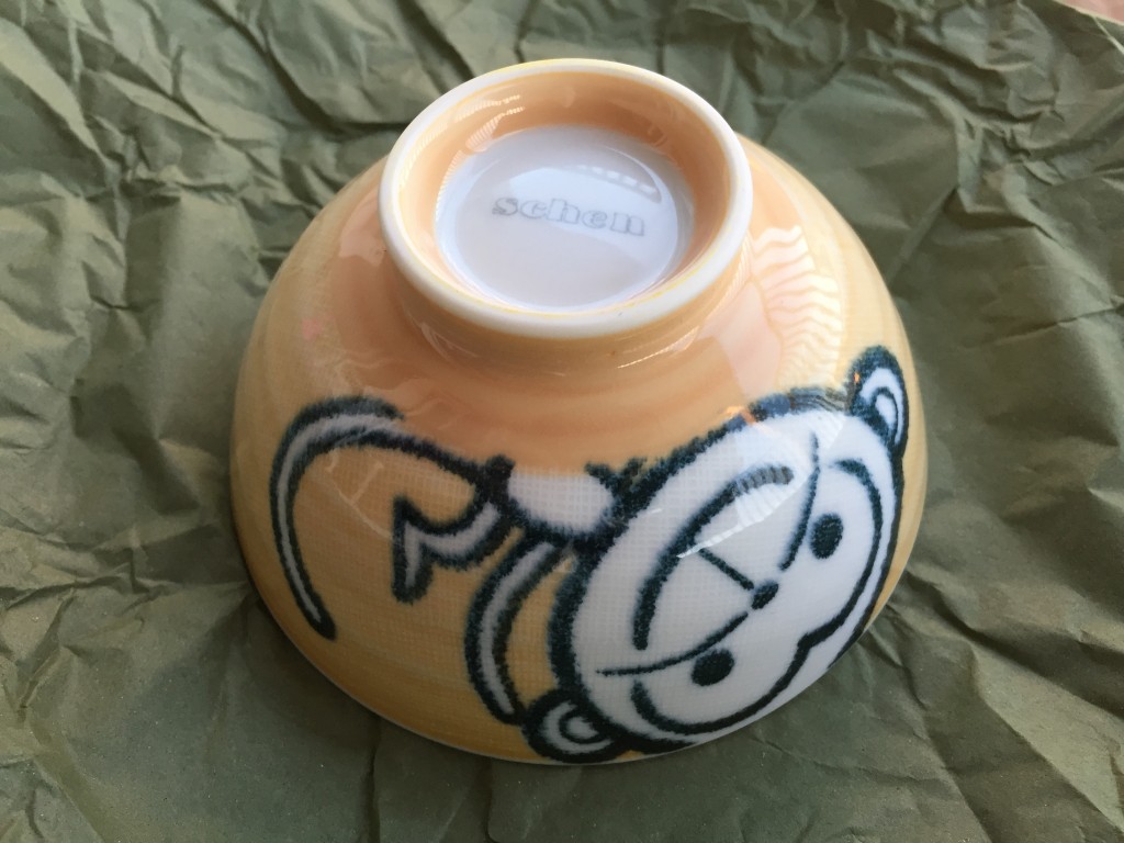 small yellow bowl with cartoon monkey design on side