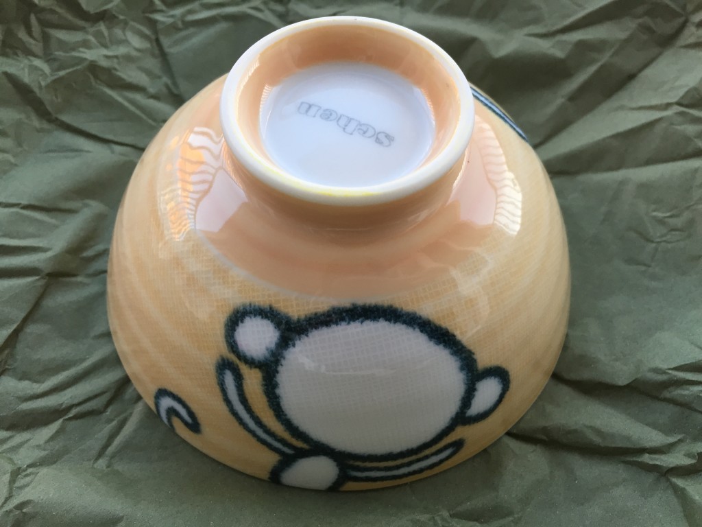small yellow bowl with back of cartoon monkey outline on side