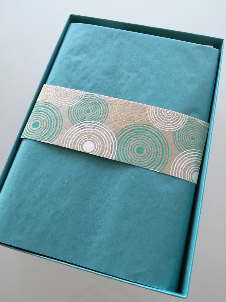 yuzen november-january 2014 winter box open with teal tissue paper and piece of yuzen paper