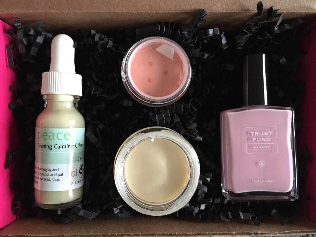open contents of petit vour december 2014 box with blissoma evening calming facial creme, everyday minerals matte blush, meow meow tweet deodorant cream, and trust fund beauty nail lacquer