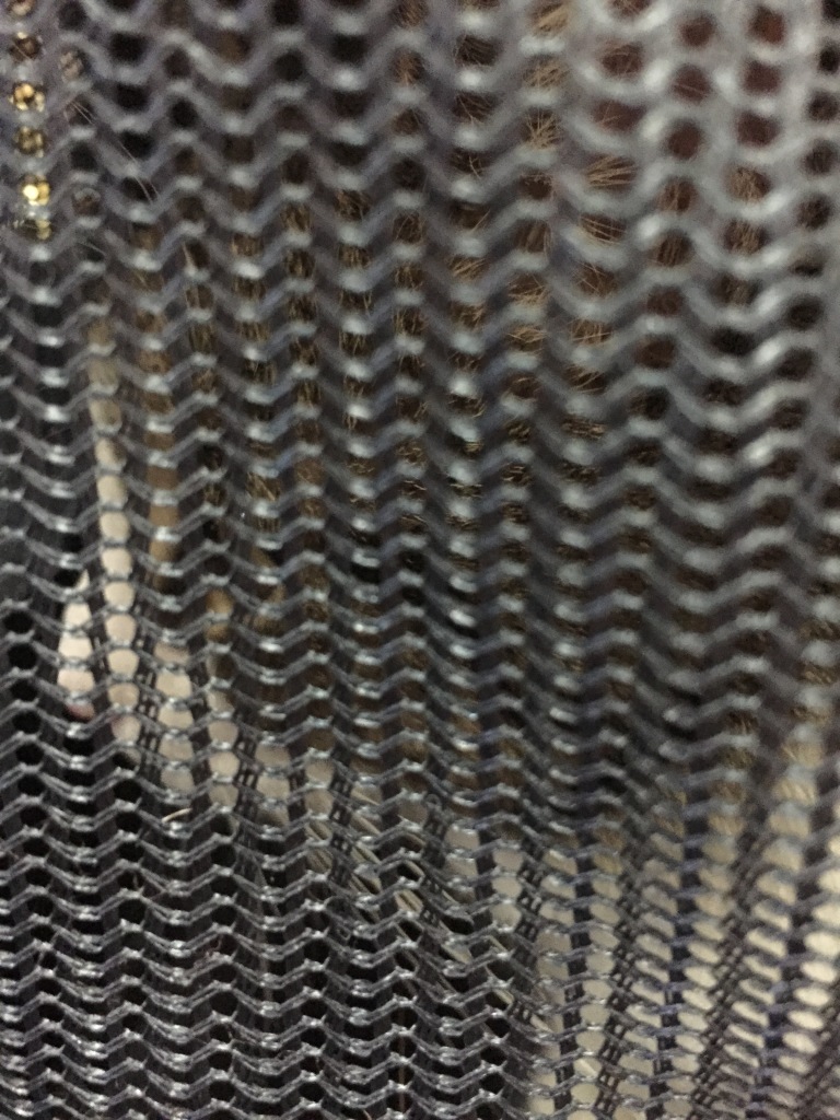 cat face through mesh web of carrier