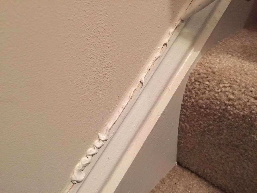 midway through caulking process with globs of caulk covering crack