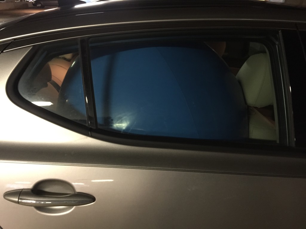 giant blue beach ball squished in back seat of car