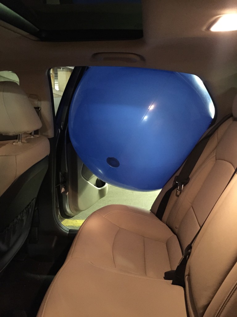 giant blue beach ball stuck in door of car