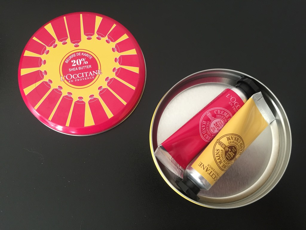 inside of l'occitane collector's tin with two mini hand creams