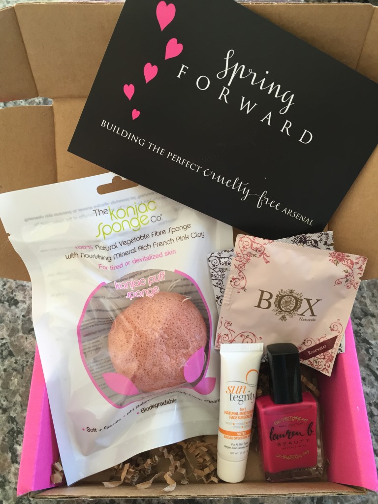 contents of petit vour april 2015 box with the konjac sponge co puff, box naturals luxe towelettes, suntegrity tinted face sunscreen, lauren b nail polish, and info card with spring forward theme