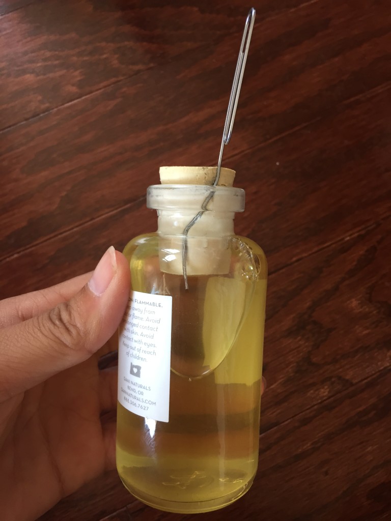 dani naturals reed diffuser bottle with paperclip trying to move stopper
