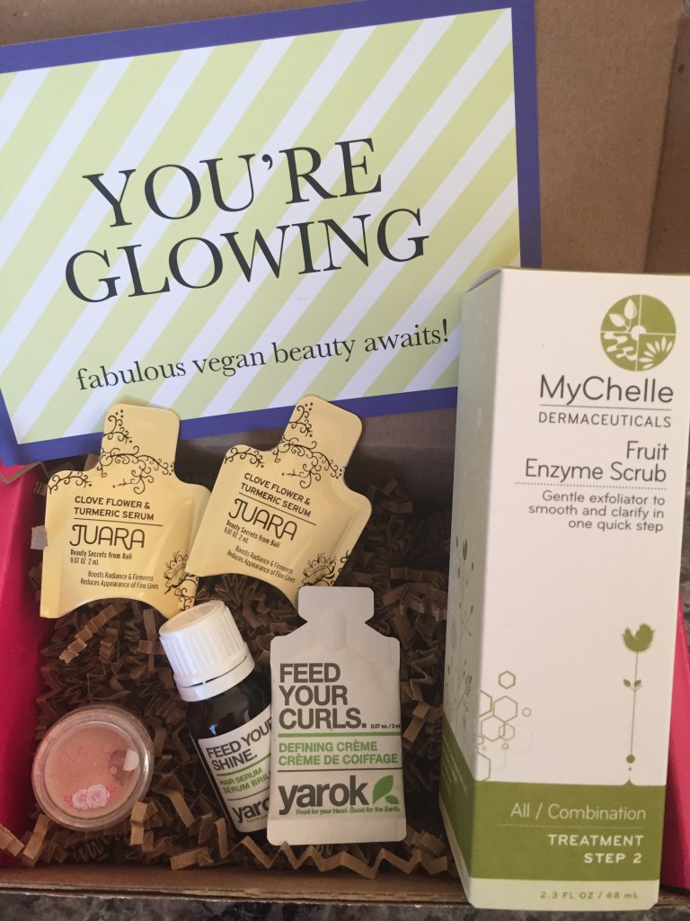 contents of petit vour august 2015 box with juara serum, modern minerals finishing glow, yarok serum and defining creme, mychelle enzyme scrub, and info card with you're glowing theme