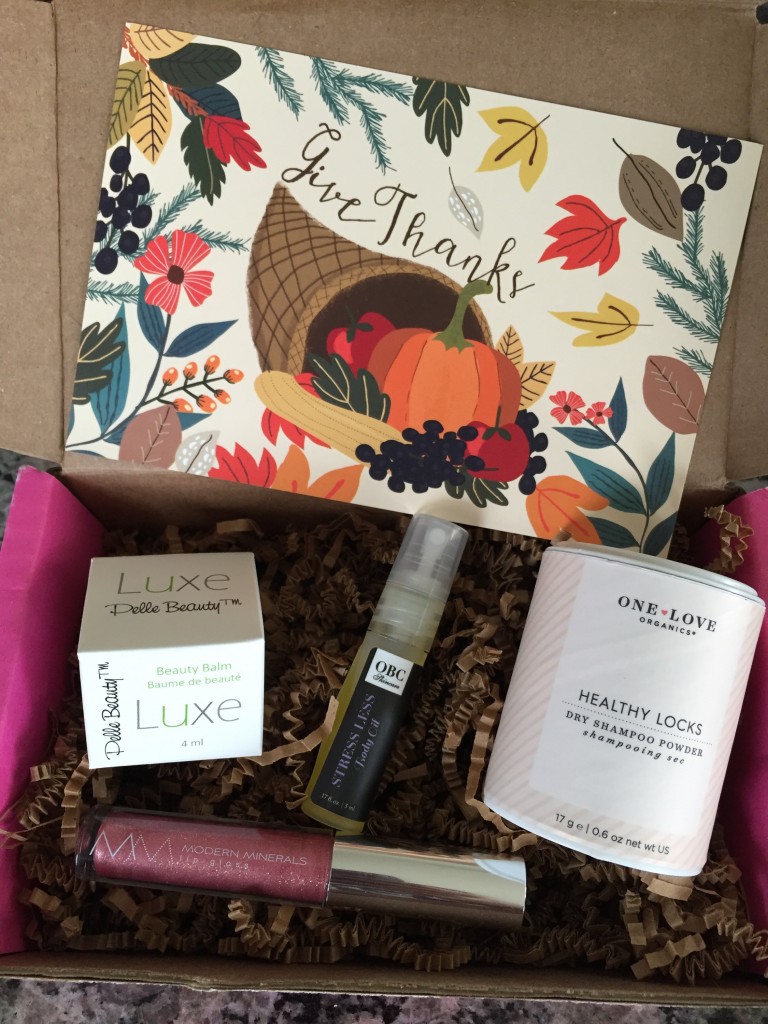 contents of petit vour november 2015 box with pelle beauty beauty balm, obc skincare body oil, one love organics dry shampoo, modern minerals lip gloss, and info card with give thanks theme