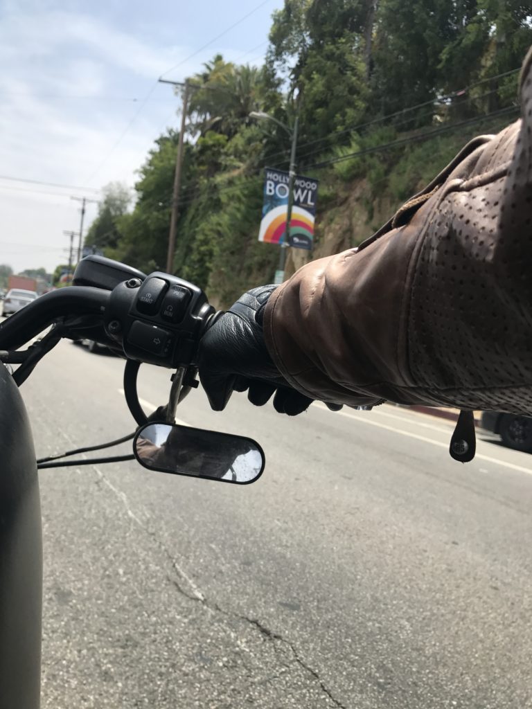 arm of motorcycle driver and view of road